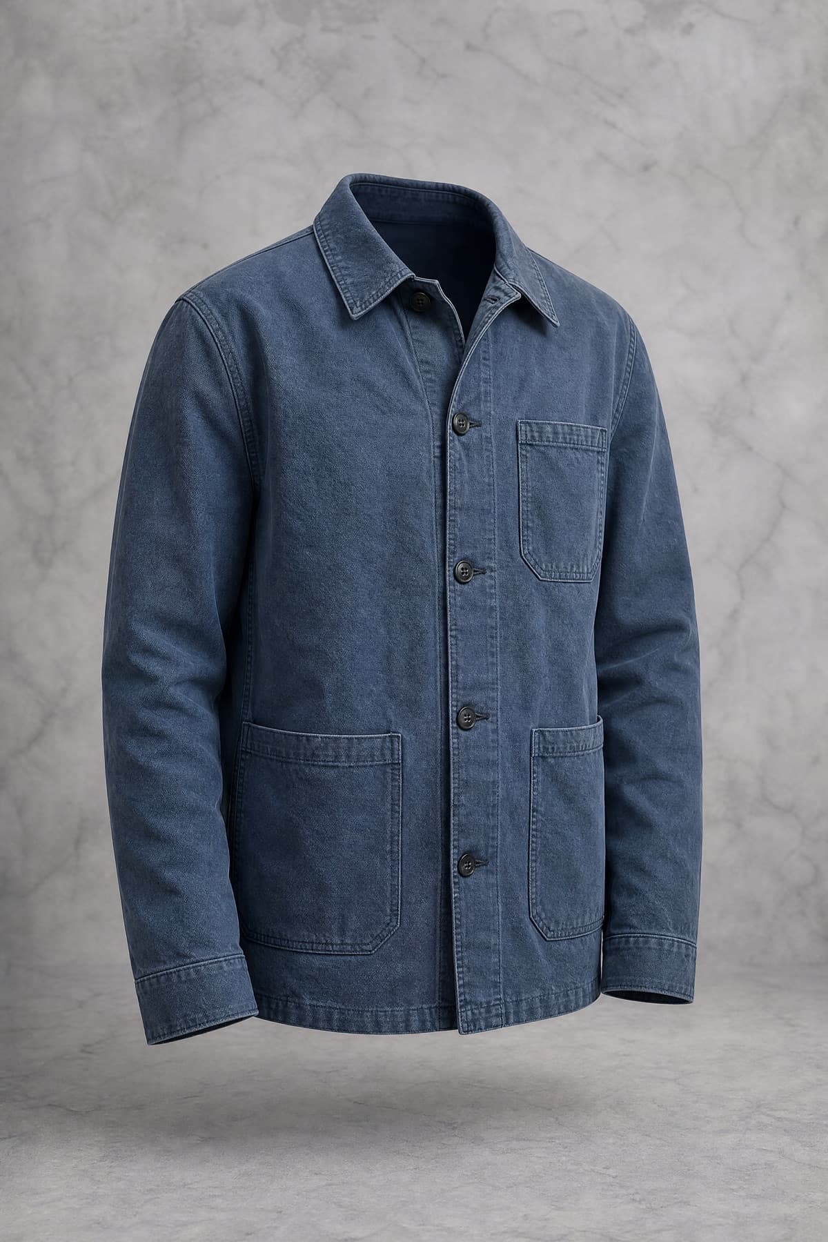 A washed indigo cotton twill chore jacket with three patch pockets