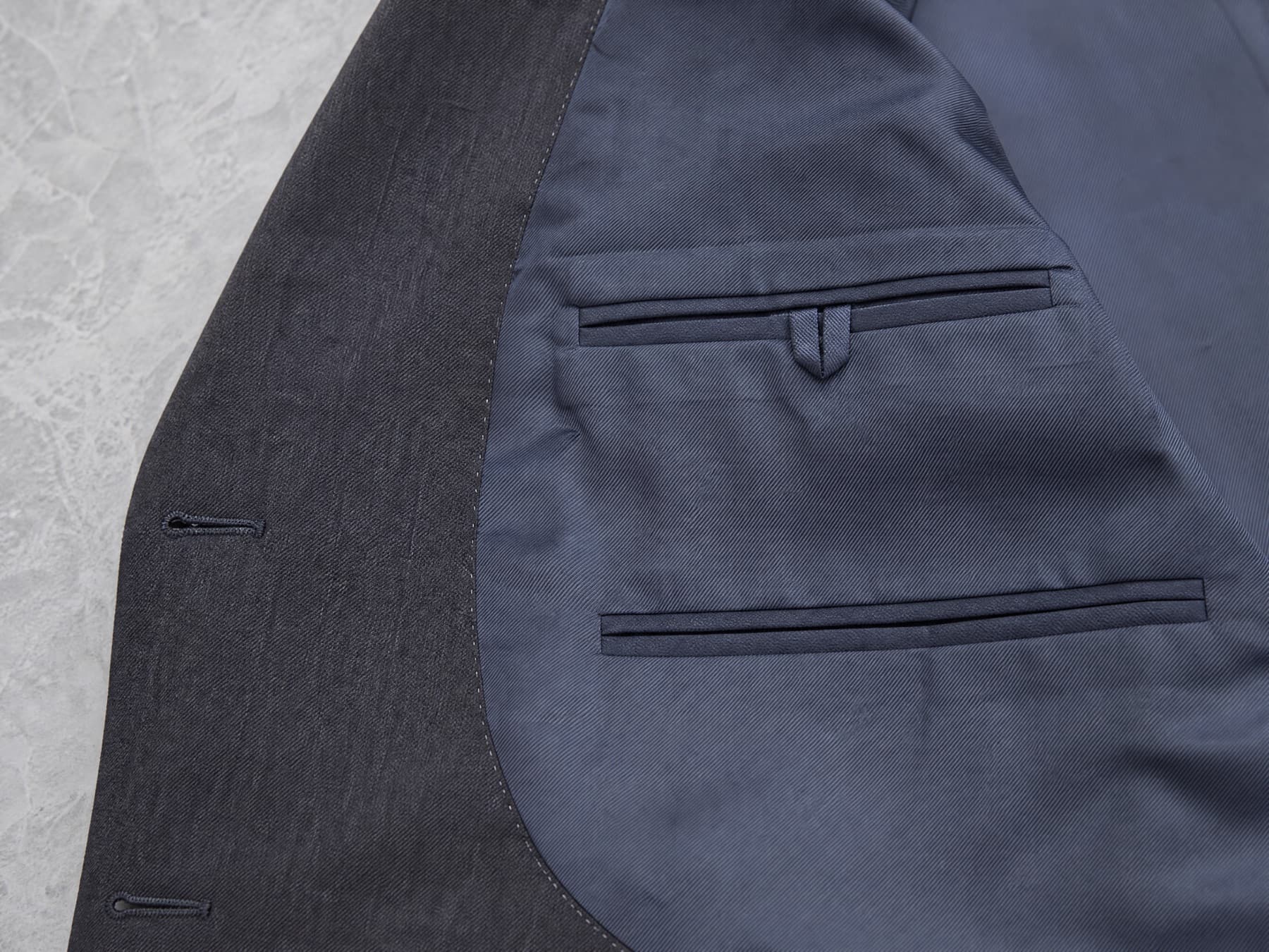 The inside front: facing panel, lining and two welted interior pockets