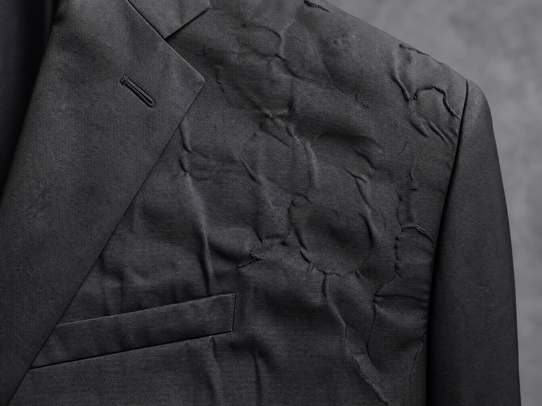 Raking light across a fused chest panel that has delaminated into visible ripples