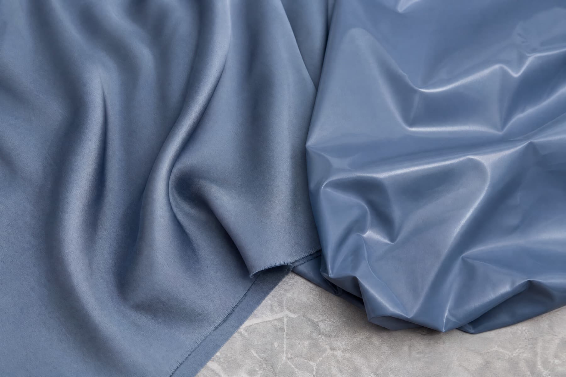A cupro lining with a dry silk-like lustre beside a polyester lining with a harder sheen